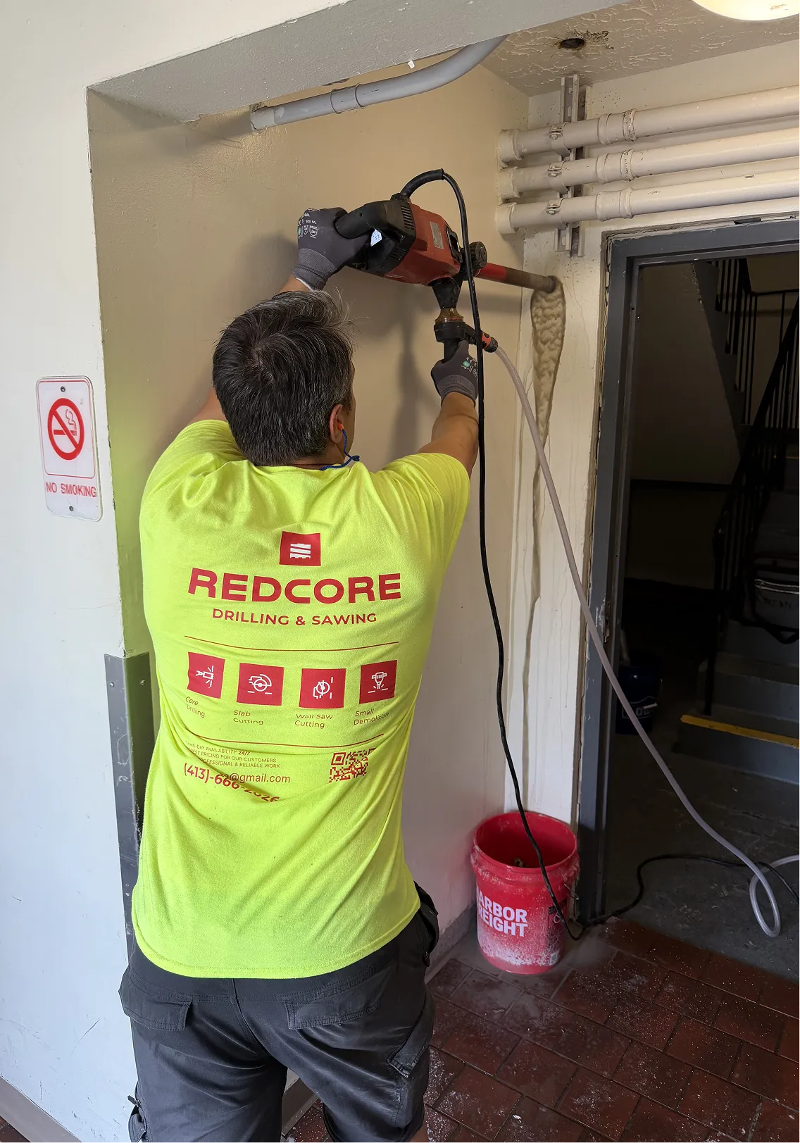 Core drilling into concrete wall